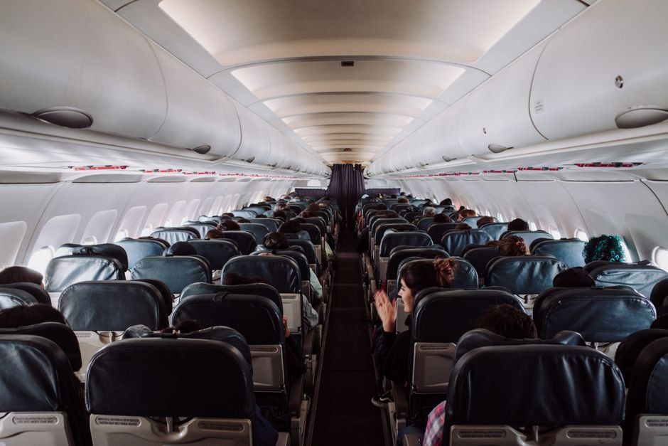 An airplane cabin interior showing rows with window and aisle seats