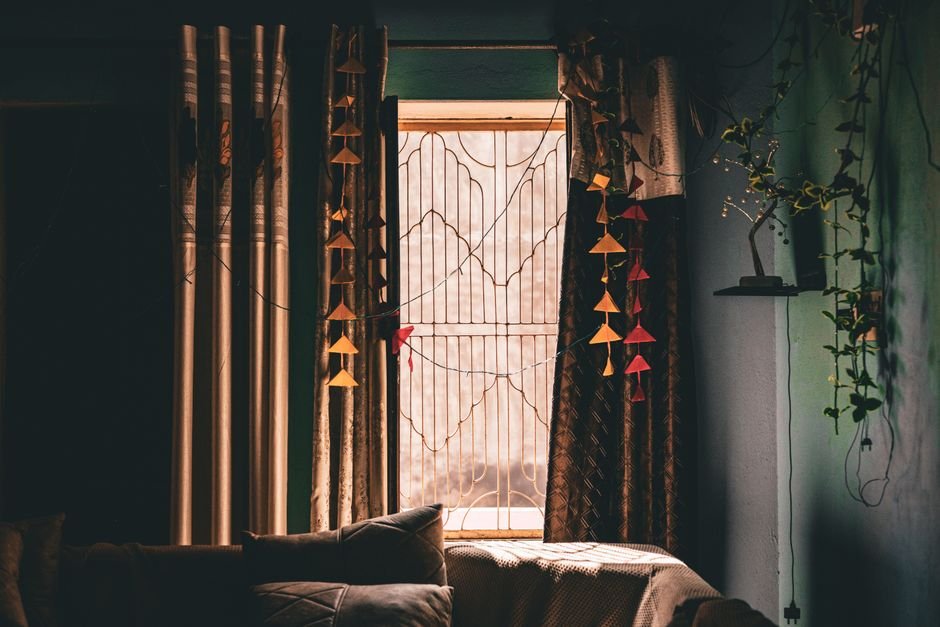 Floor-length curtains hanging beside a living room window