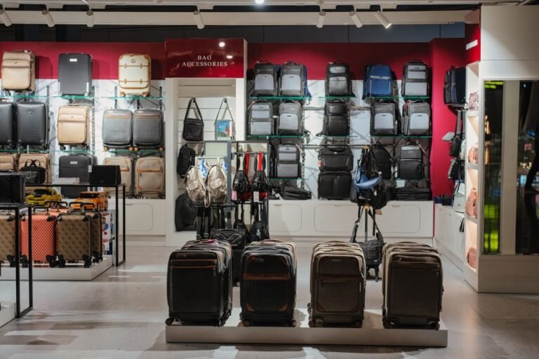 An open checked suitcase and a smaller carry-on bag side by side on a bed, partly packed