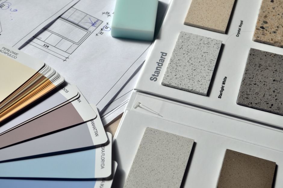 Paint swatches in different sheens fanned out on a wooden table