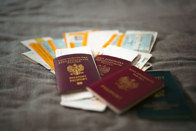 A passport, plane tickets, and travel documents arranged on a desk