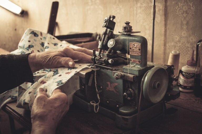 A person hand-sewing a repair into a piece of clothing