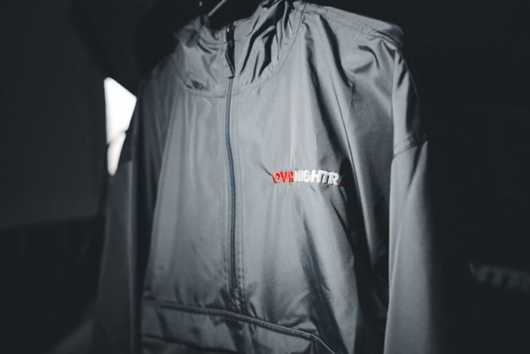 Close-up of a rain jacket's inner seam showing waterproof tape over the stitching