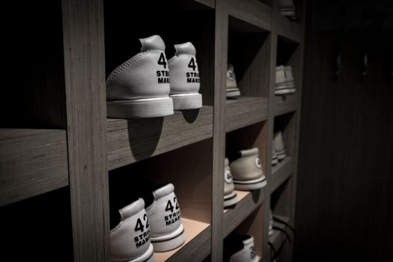 A row of shoes fitted with wooden shoe trees on a closet shelf