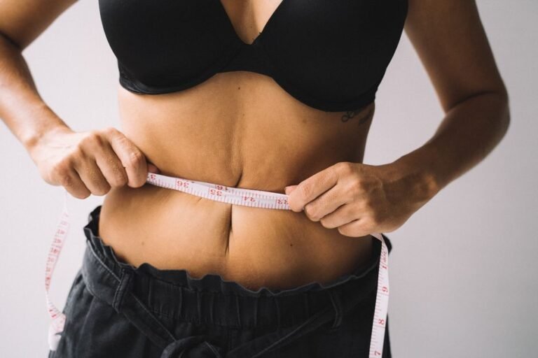 A soft tape measure laid next to a bra on a flat surface