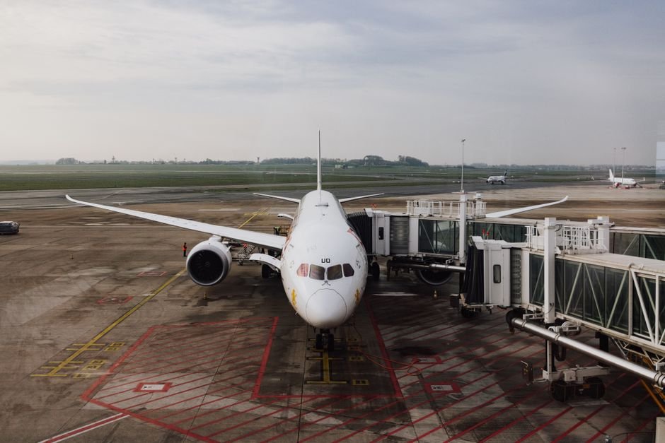 A tired traveler resting in a seat at an airport departure gate