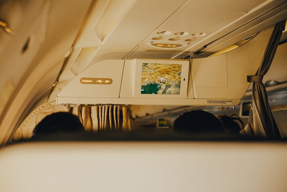 An airline seat map on a laptop screen with several seats near the front of the cabin highlighted