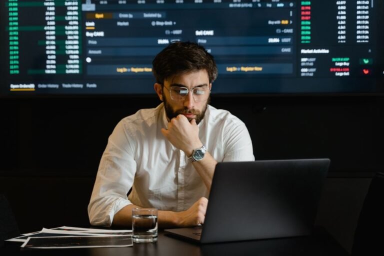 A person at a desk comparing hotel and flight prices across two browser windows on a laptop
